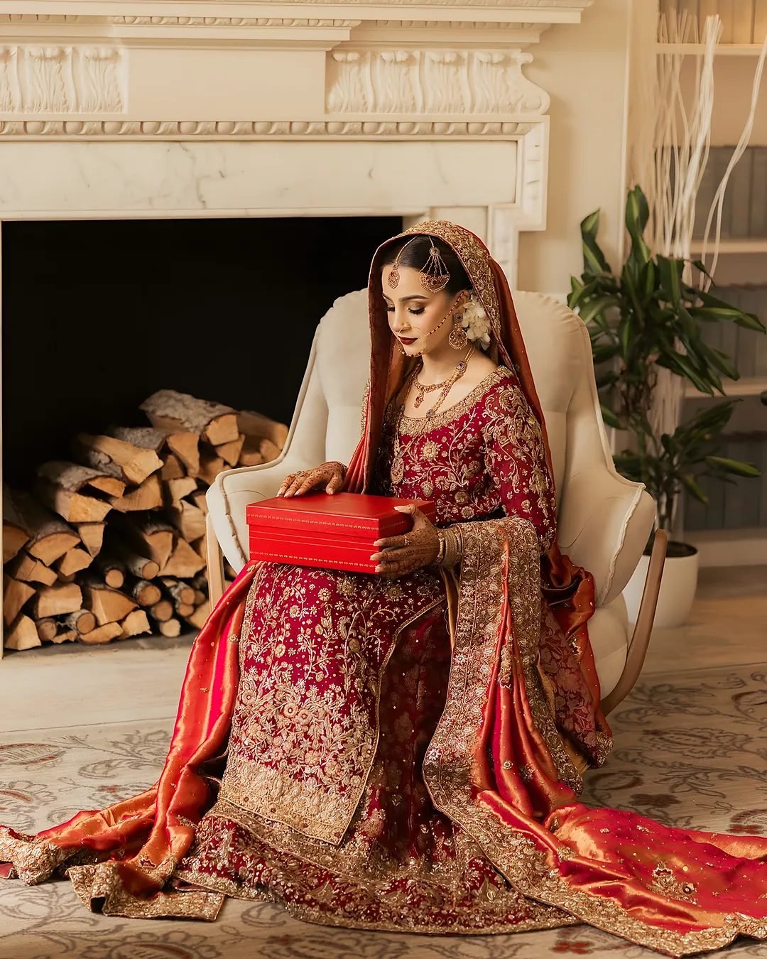 Bride by a fireplace in a red outfit