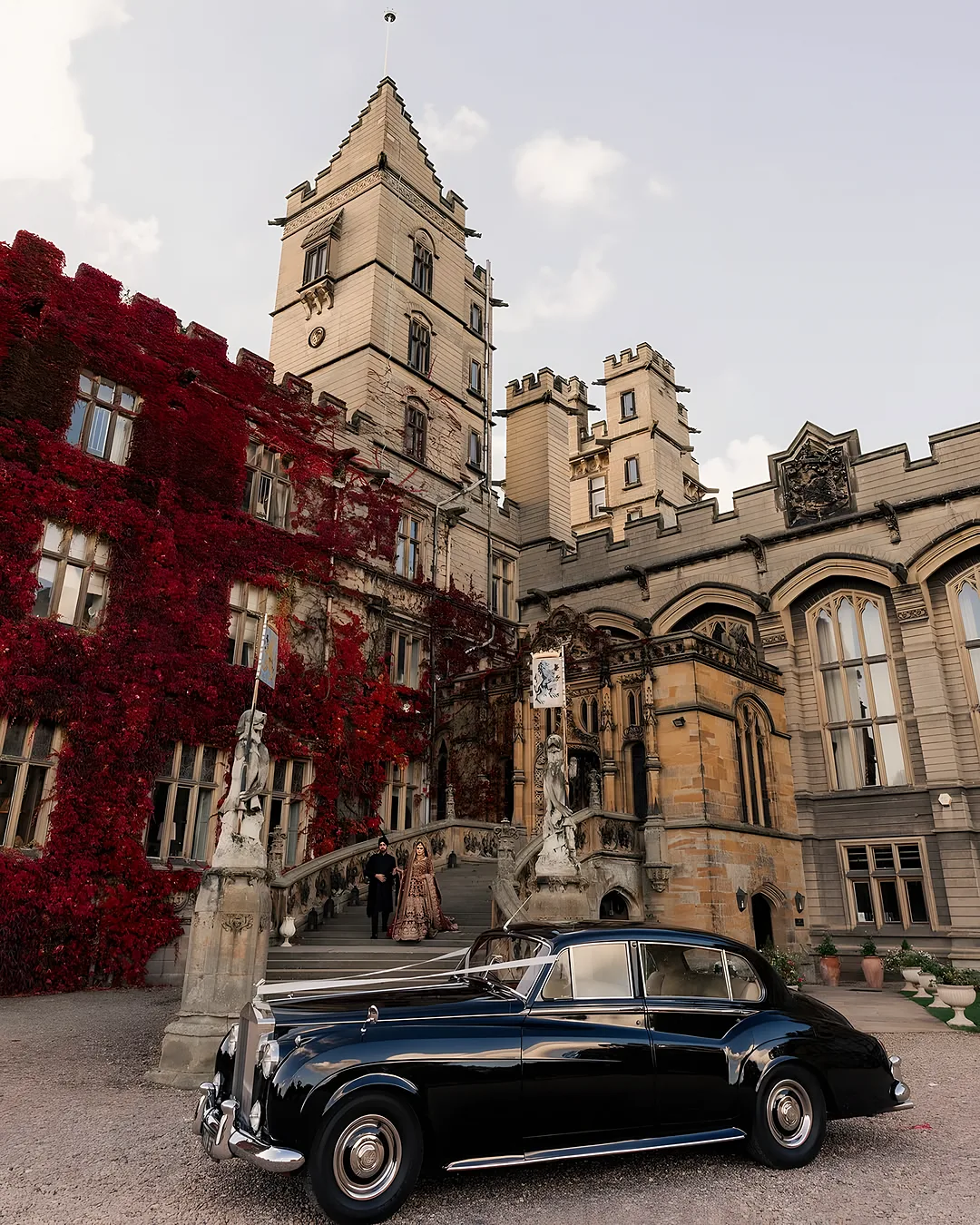 Vintage car outside an ivy-covered castle