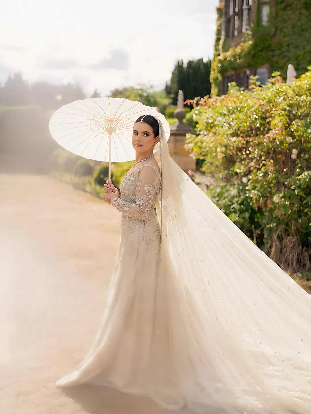 Bride with a lace parasol in a garden